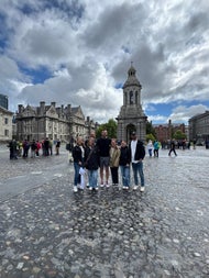 A small group of people posing in a courtyard at Trinity College in Dublin