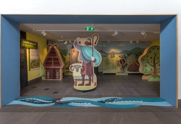 Exhibition with a cut out of a sheep and a shepherd holding a staff