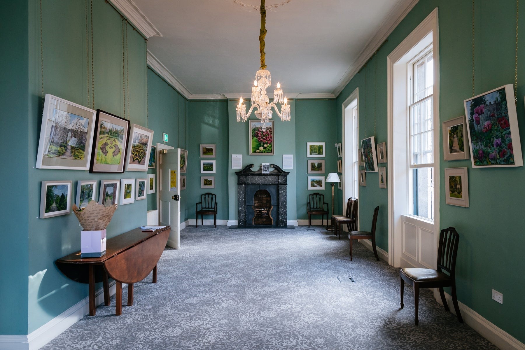 A large room with antique furnishings and décor with an ornate fire place at the top of the room