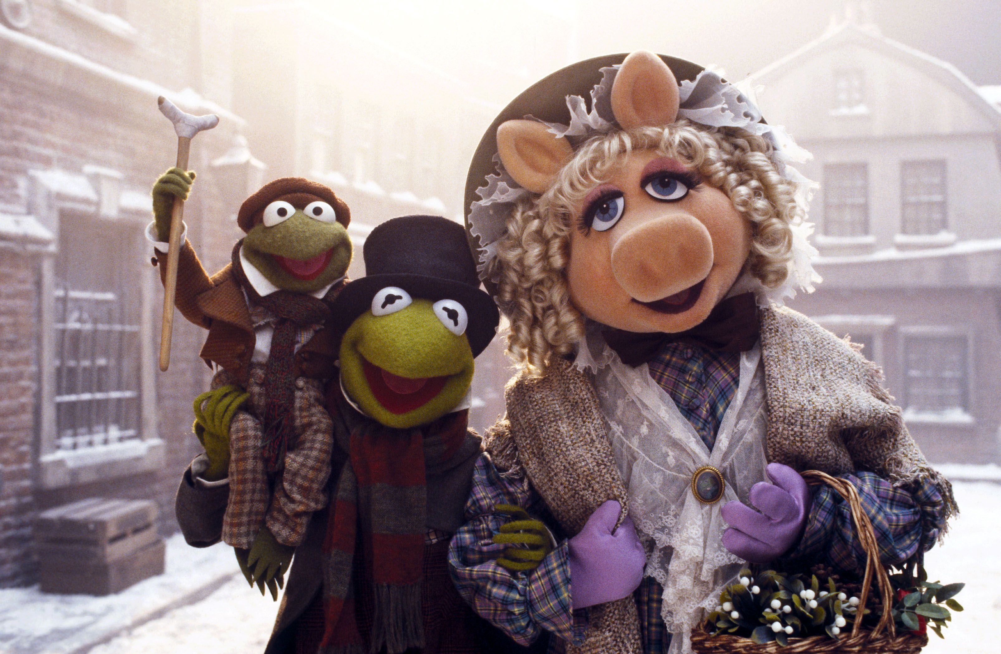 Kermit the Frog, Miss Piggy and Robin the Frog. Their clothes and background suggests a Victorian-era winter.