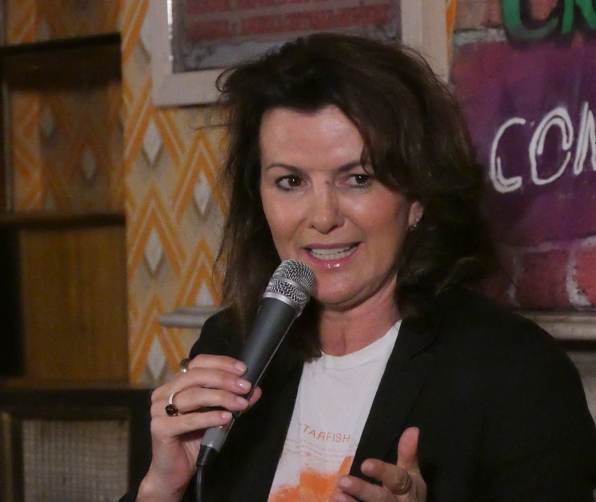 A woman comedian with a microphone in her hand