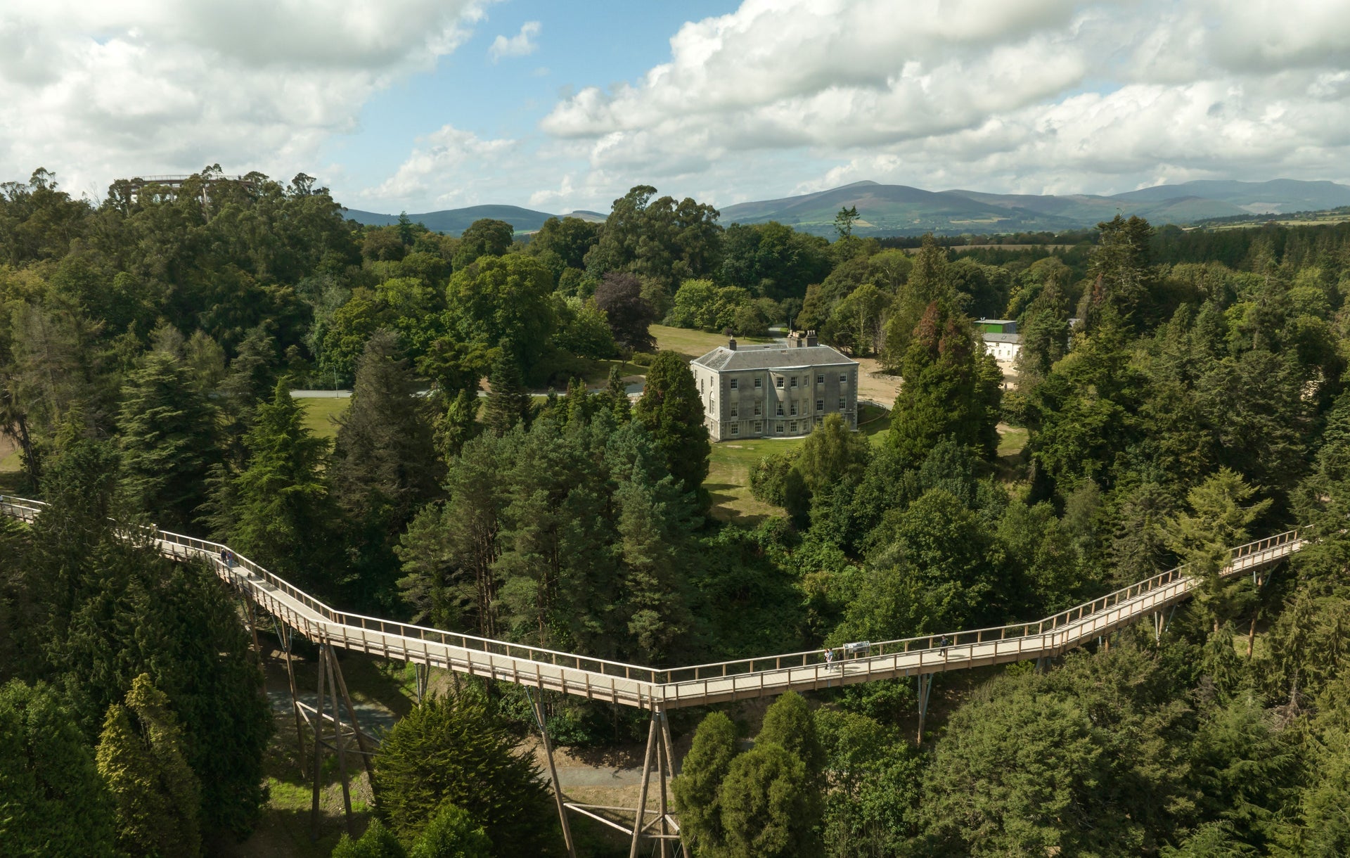 An aerial view of the treetop walkway with Avondale House in the background