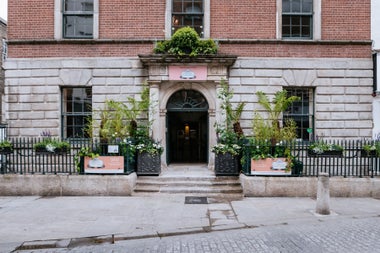The exterior of a Georgian house with plants either side of the entrance