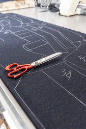 A pair of scissors on the sketched cloth in preparation of cutting the garment designs