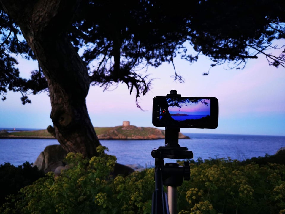 A mobile phone on a stand ready to take a sunset picture