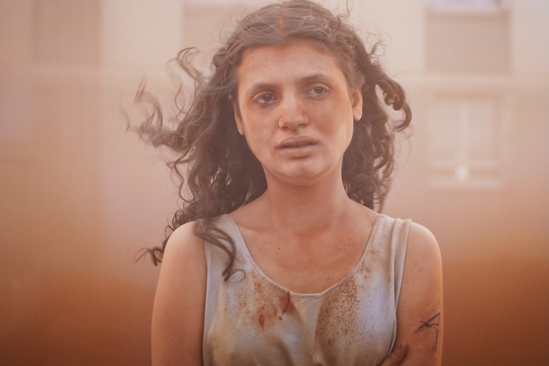 A disheveled young girl with an distraught expression, covered in dust.