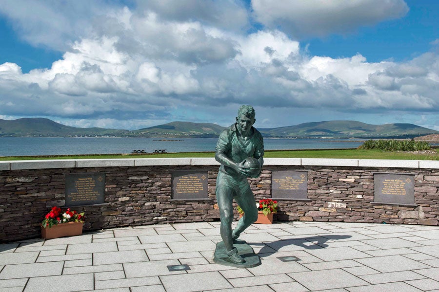 Bronze statue of Kerry footballer Mick O Dwyer with the background of the bay visible behind