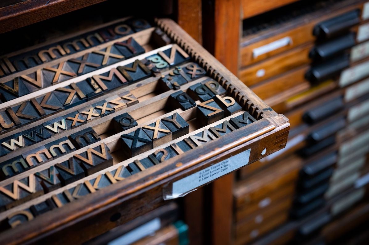 Image of a wooden tray of small print letters made from wood and metal.