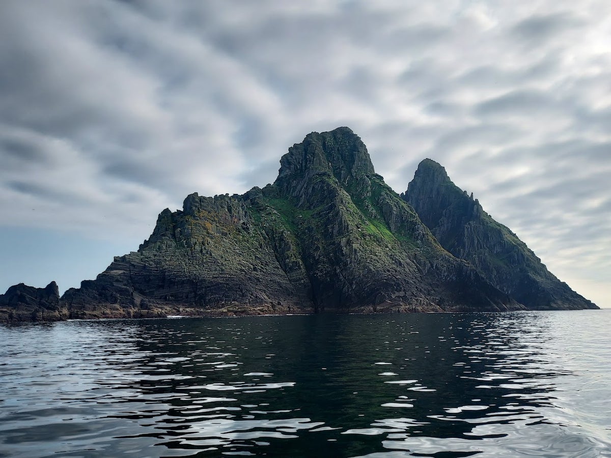 A triangular shaped rocky island in the ocean