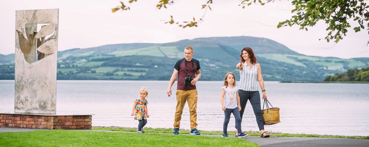 A family walking along a lake shoreline