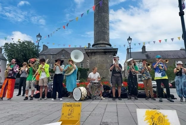 Birr Vintage Week & Arts Festival 2026, a large group of musicians playing outdoors standing in a line under a tall column