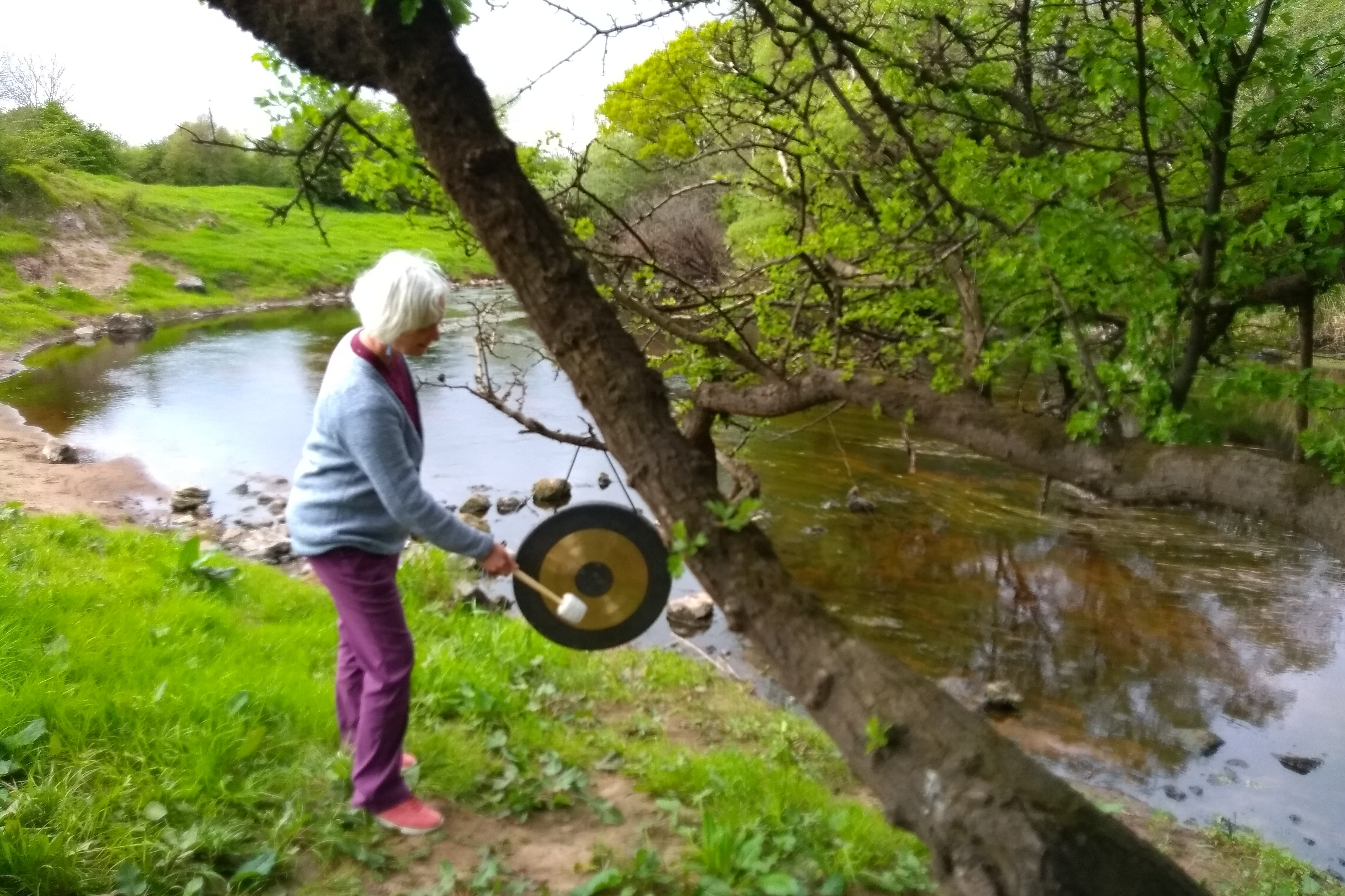 The guide Jackie using sound healing by a tree
