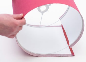 A participant smooths the fabric around a frame while assembling a handmade lampshade
