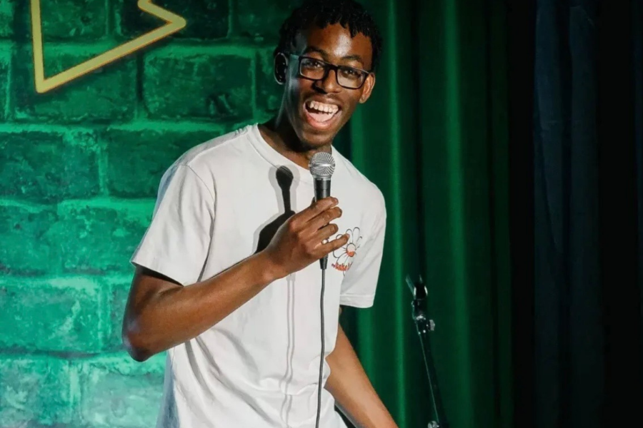 A smiling man holding a mic