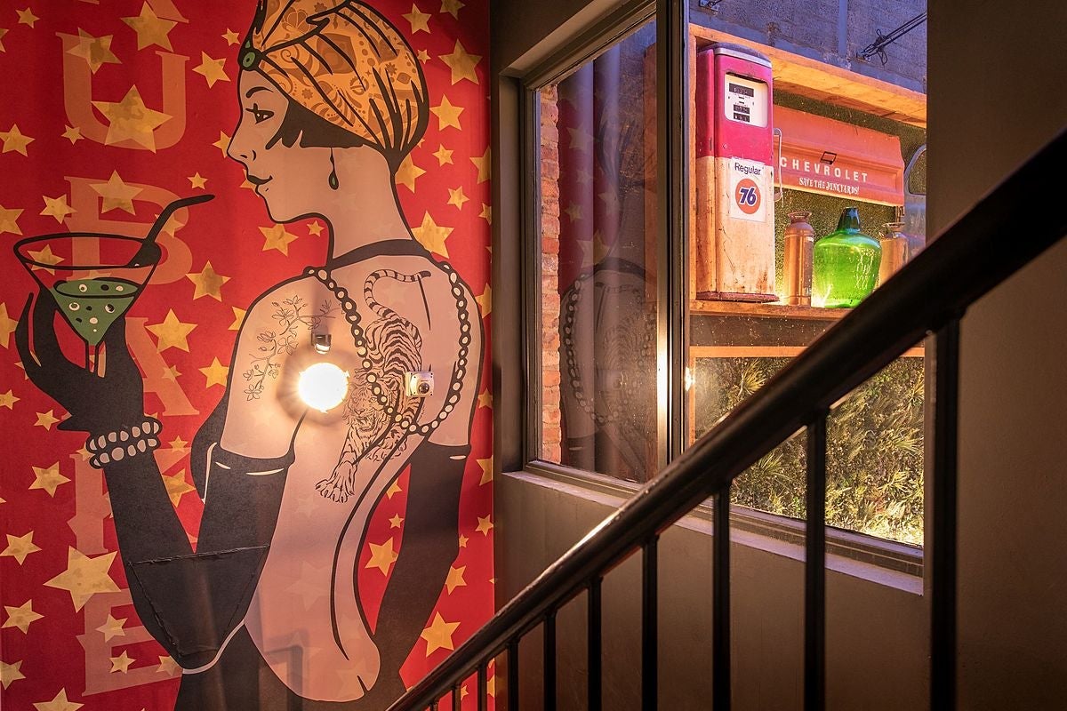 A painting of a lady drinking a cocktail in Brubakers Bar & Restaurant