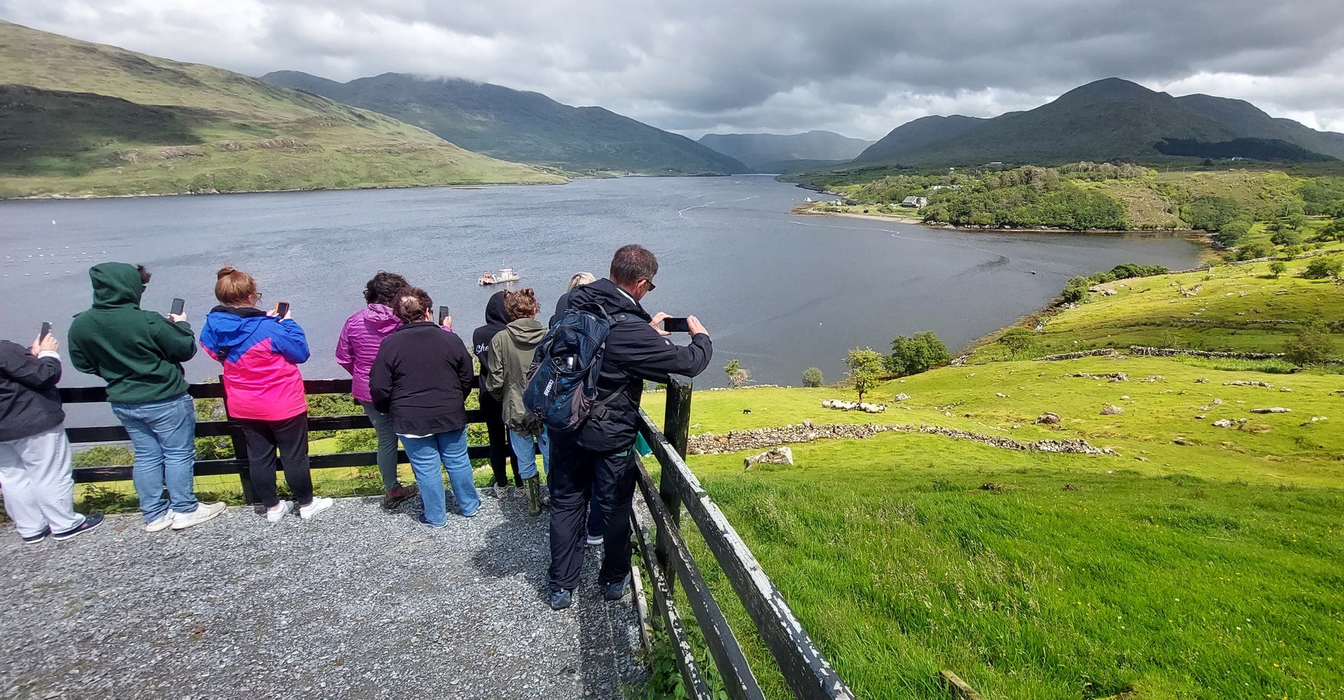 A tour group at a viewing point looking out onto a lake
