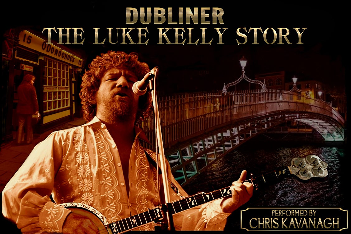 A man with curly hair is playing guitar and singing into a mic.