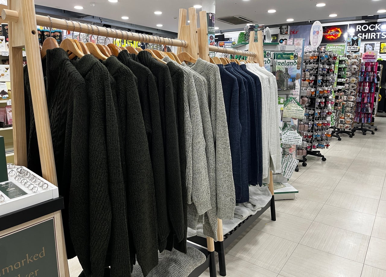 Selection of woollens on a rail surrounded by other Irish gifts and souvenirs for sale