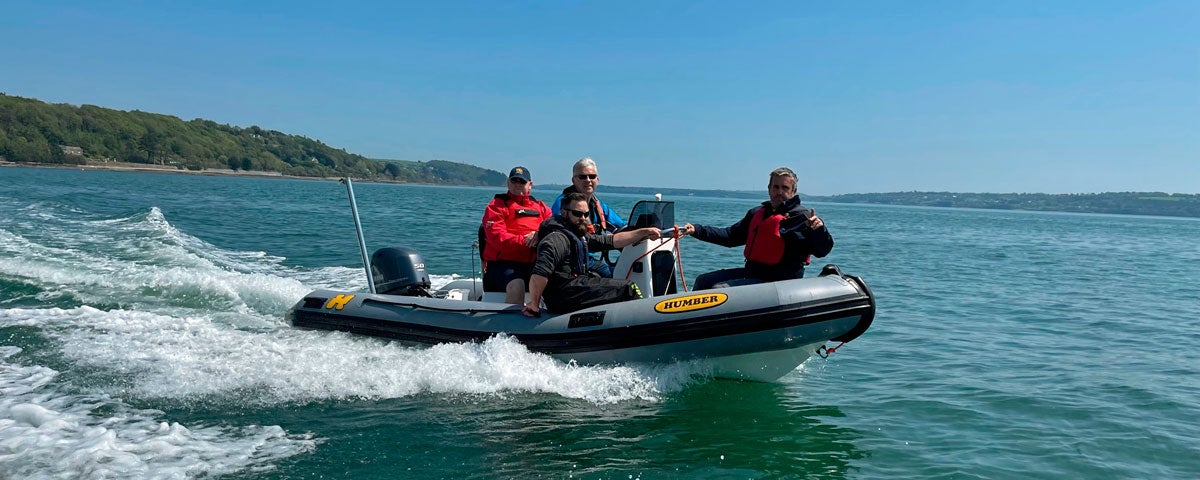 Four men on a motor powered dinghy on the sea