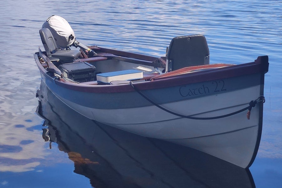 Small boat called Catch 22 moored up on a lake