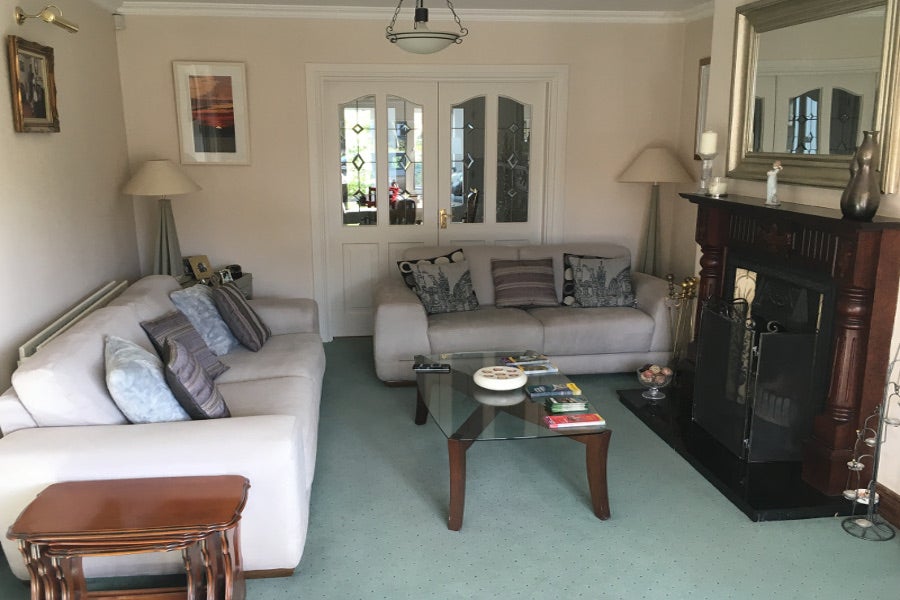 Sitting-room with cream chairs and green carpet