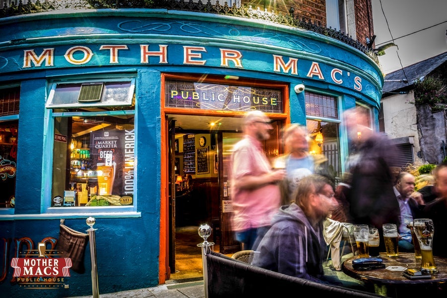The exterior of Mother Macs pub with people standing outside