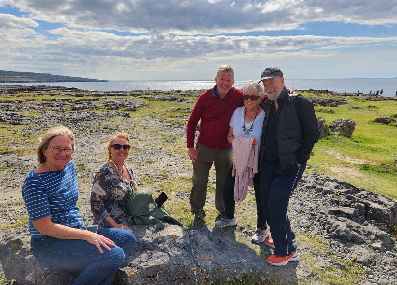 A group of people on tour with the ocean in the background