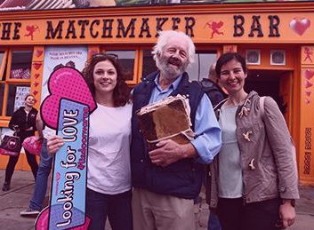 3 smiling people standing in front of a pub