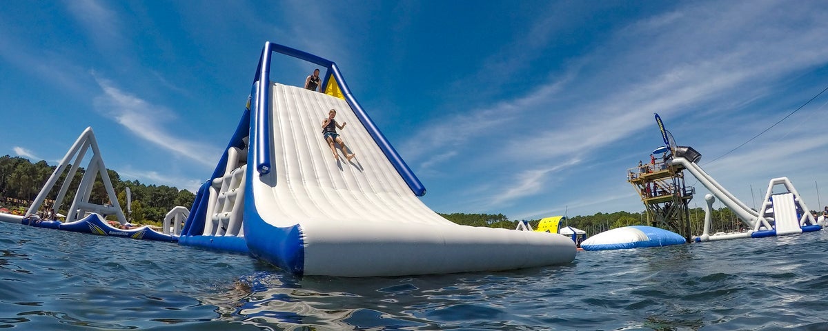 Someone sliding down an inflatable slide on a lake