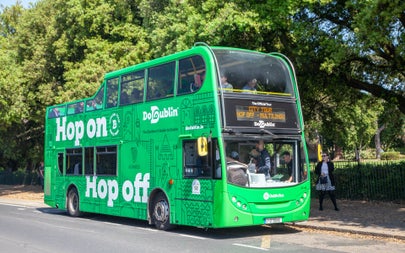 A double decker bus with a tour group on the streets of Dublin