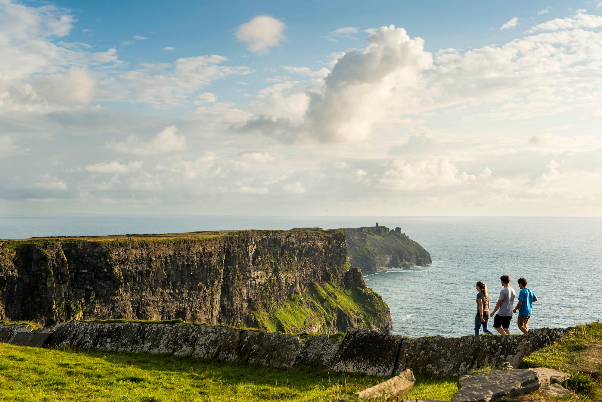 People walking along the Cliffs of Moher in Co Clare
