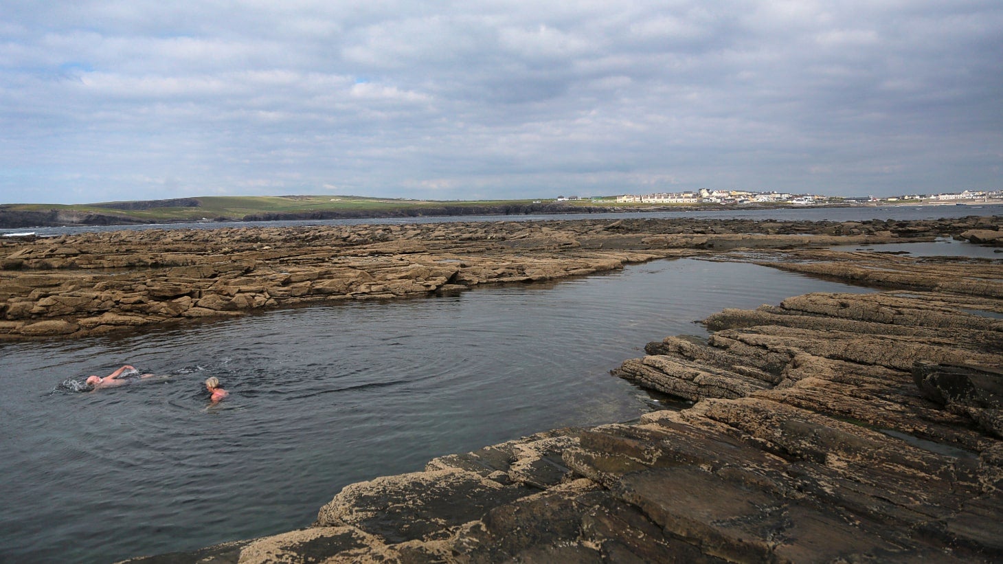 Two people swimming at The Pollock Holes in Kilkee, Clare