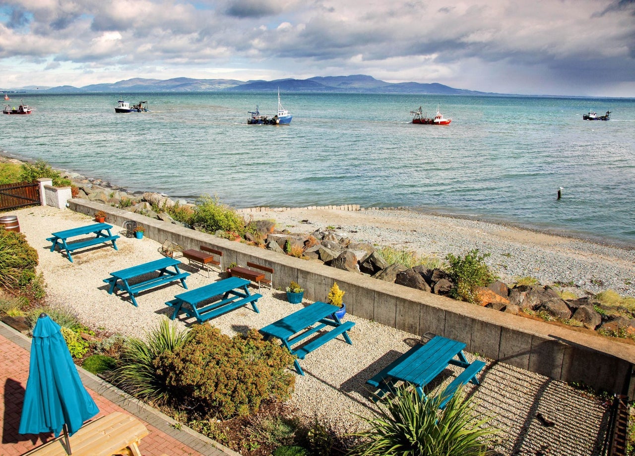 A view of the sea and fishing boats from restaurant with picnic benches