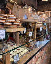 Treats and cakes on display in a glass case and red brick counter in a farm shop