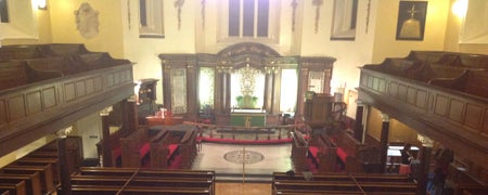 A view down from a gallery overlooking pews and an altar