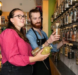 Two people looking at the jar of the botanicals for the gin