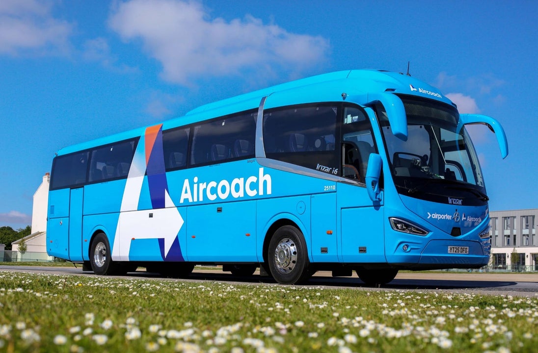 Aircoach bus parked beside a meadow