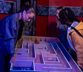 Three girls playing a maze puzzle