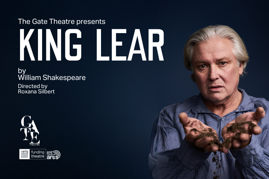 Conleth Hill appears as King Lear in the Gate Theatre. He is wearing a blue shirt, on a navy background, and holding dirt. Text reads: King Lear by William Shakespeare, directed by Roxana Silbert. Supported by the Arts Council and RTÉ.