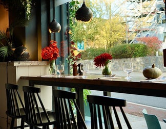 A counter lined with place settings and flowers in vases