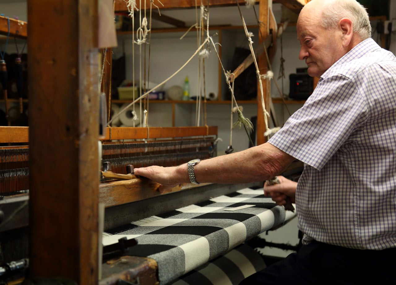 A gentleman working at a weaving loom