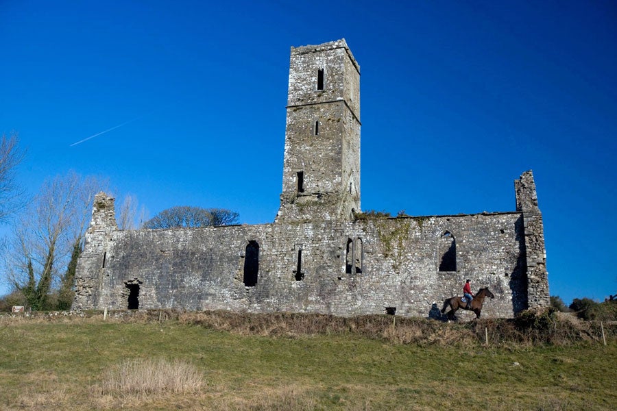 Ruins of Moor Abbey with a person on horseback near the abbey wall