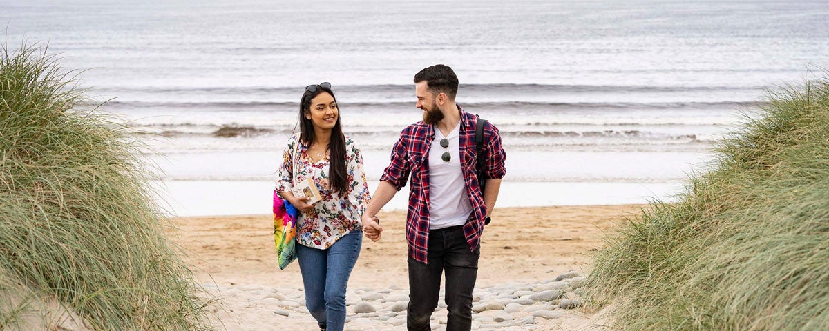 Couple walking on the beach at Doonbeg, County Clare