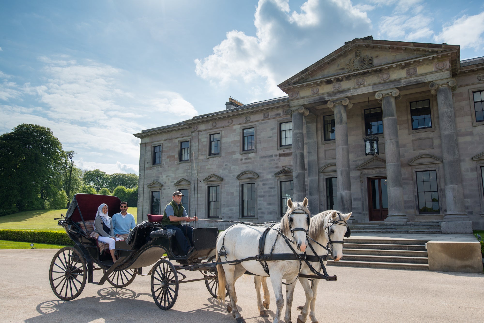 A couple in a horse drawn carriage outside of Ballyfin Demesne, Co Clare