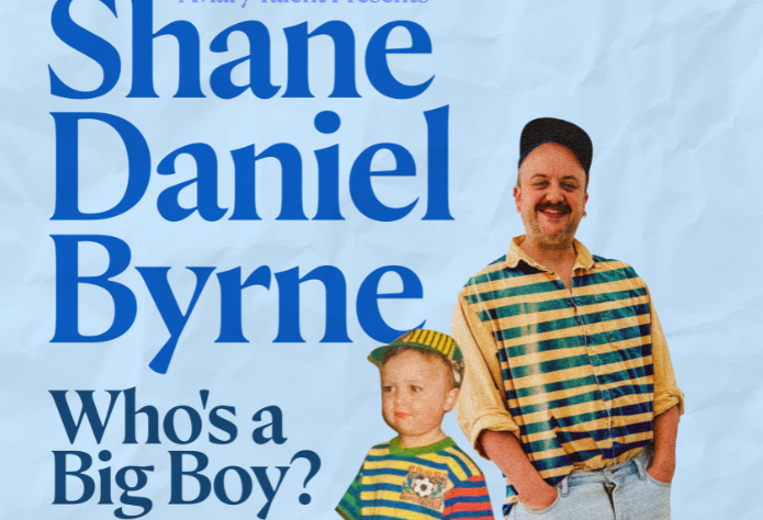 A smiling man in a stripy top standing with a young boy also in a stripy top, both with their hands in the shorts pockets.