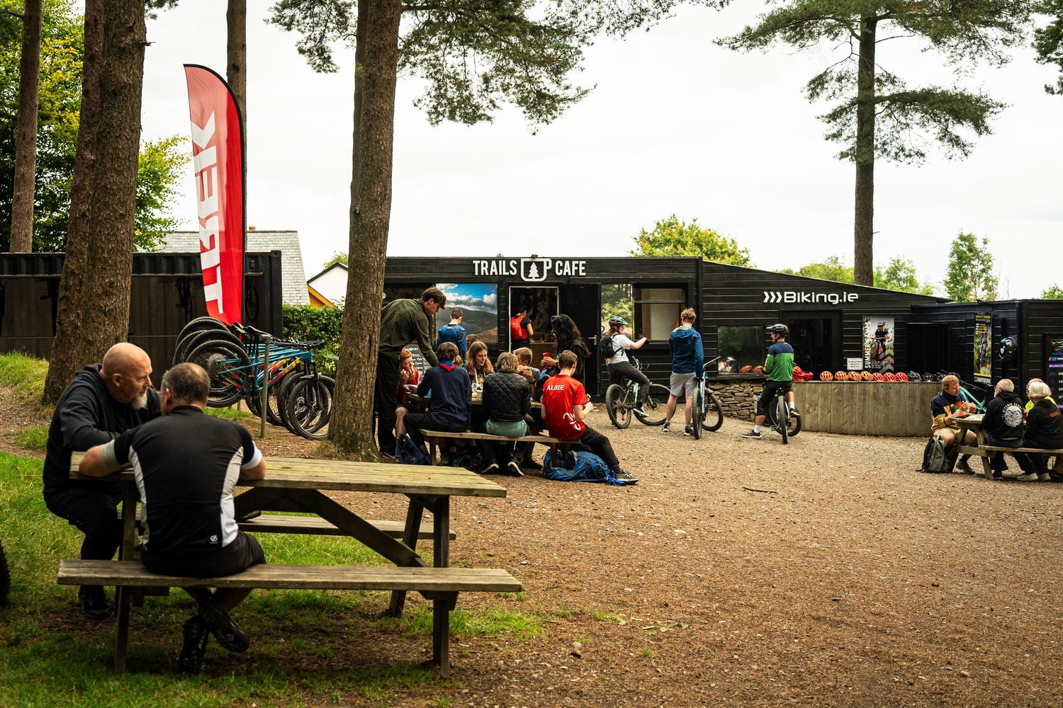 People sitting on picnic benches outside a café