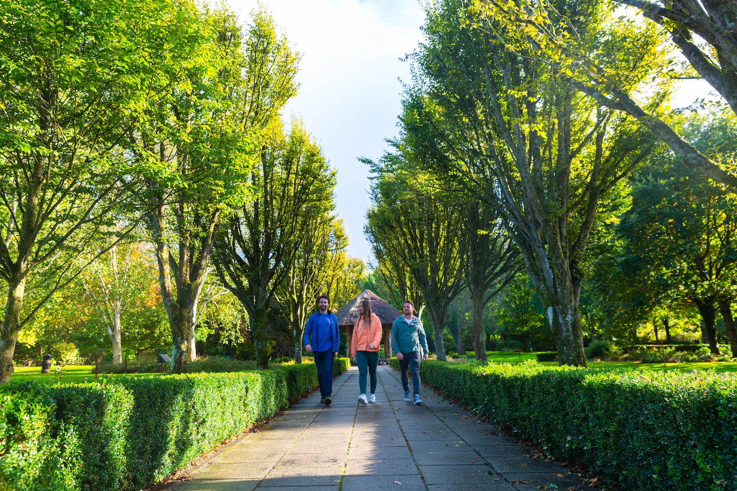 Three people walking in Adare Town Park in County Limerick.