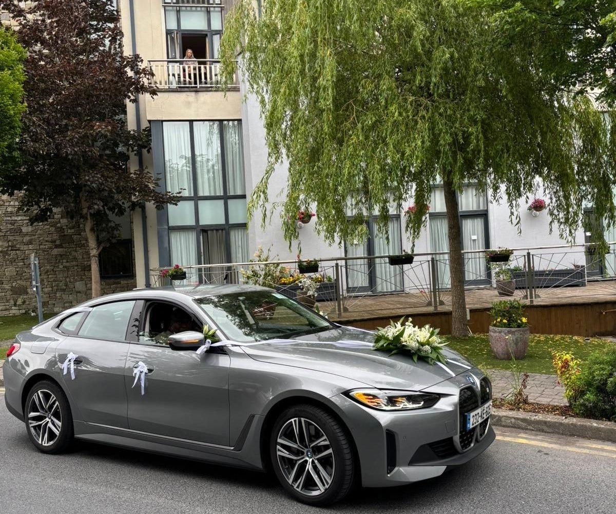 Decorated car parked on a street outside a building with an open window