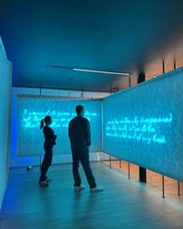 Two people standing at a visual display reading text on a screen