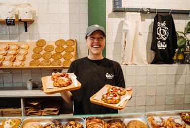 A lady standing behind the counter in a bakery
